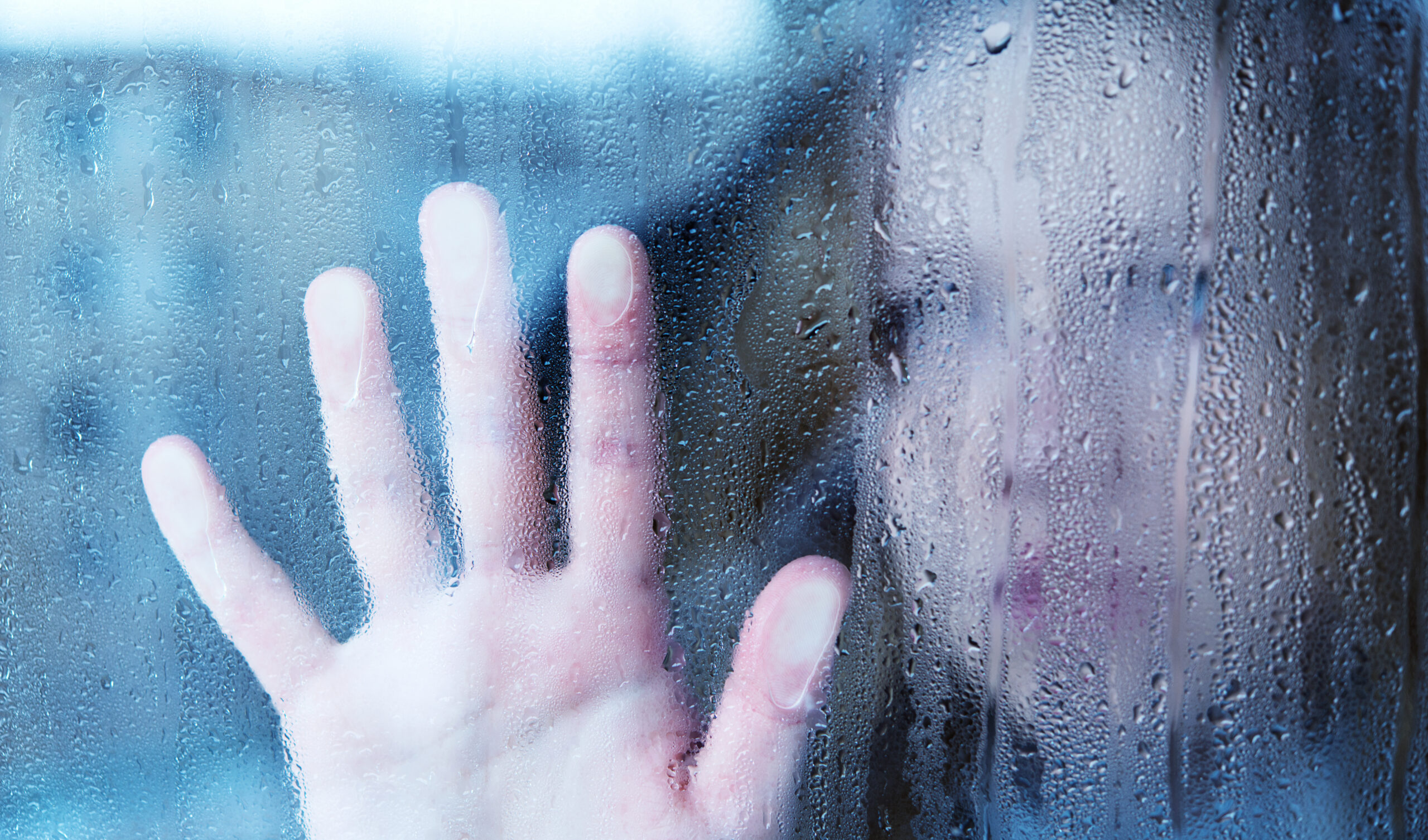 Child at window with hand on window